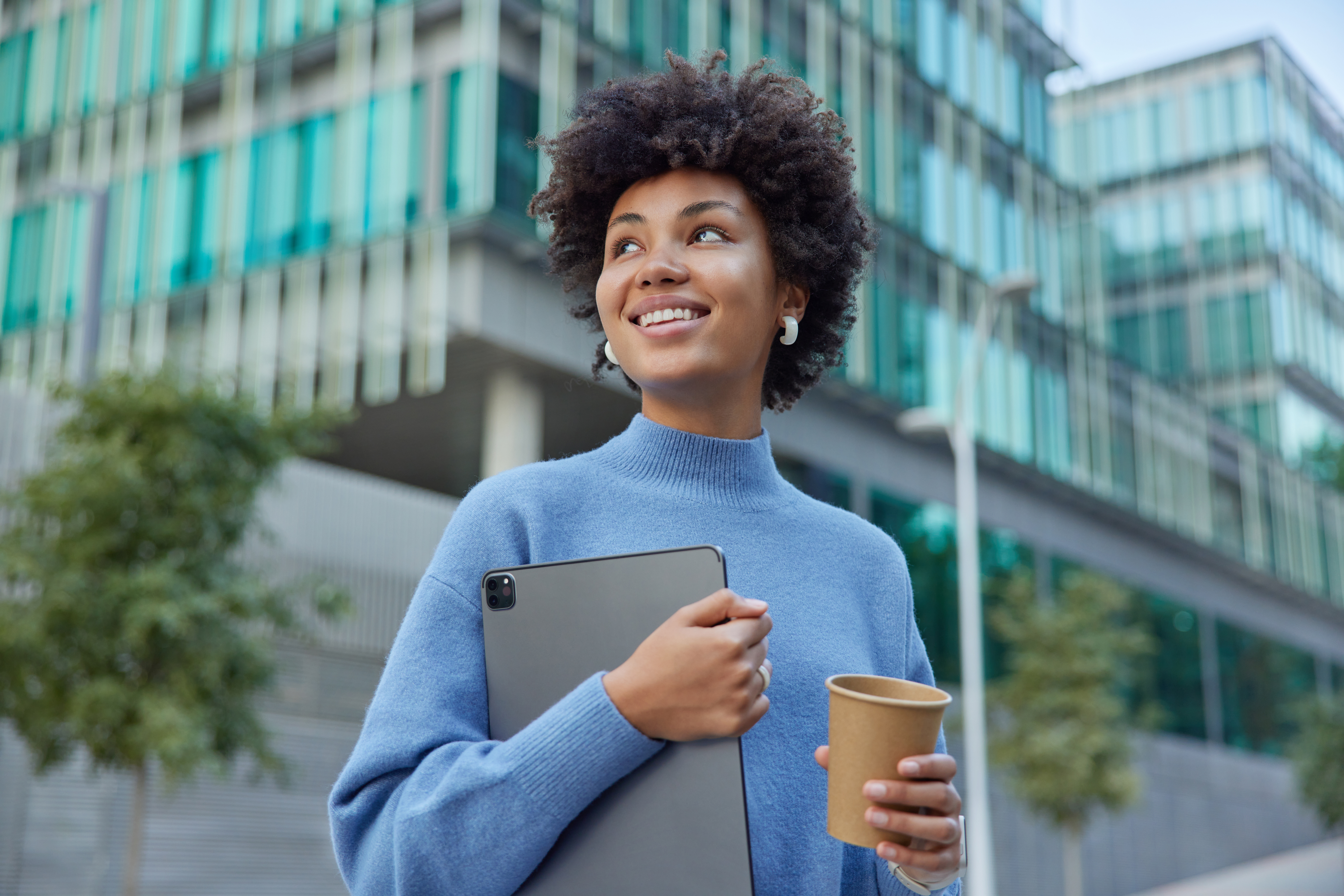 Young professional with a tablet outside office buildings
